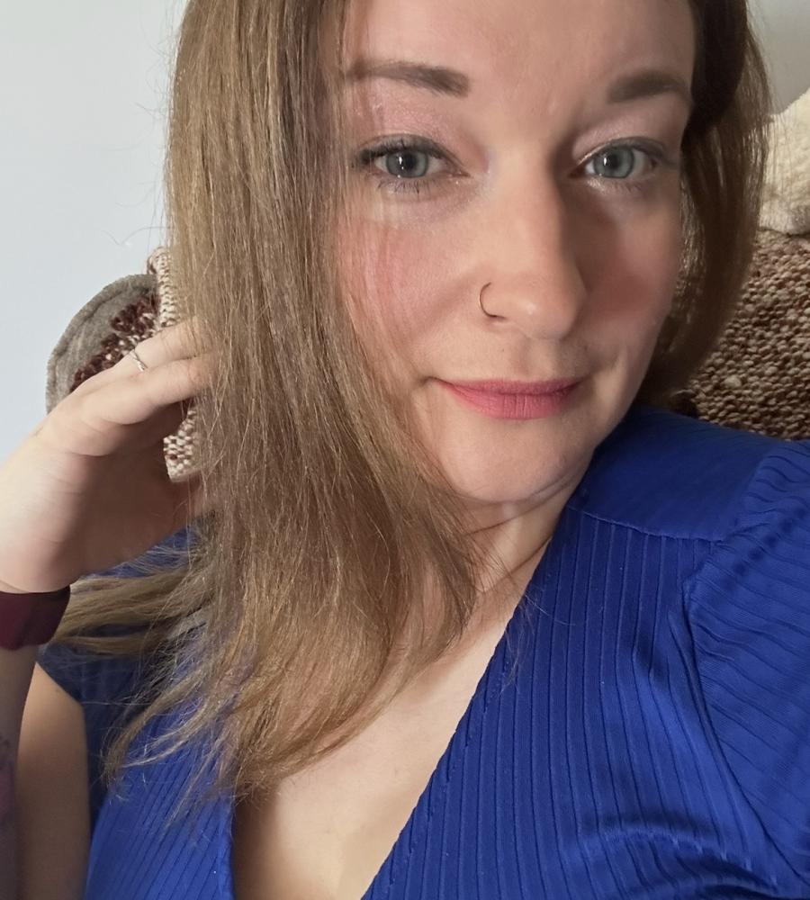 Charlena has shoulder length hair and a blue shirt on 